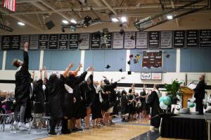 Nikiski Middle/High School graduates throw their caps into the air at the conclusion of a graduation ceremony in the schools gym in Nikiski, Alaska, on Wednesday, May 15, 2024. (Jake Dye/Peninsula Clarion)