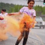 Jake Dye/Peninsula Clarion
Emily Musgrove emerges from a cloud of orange powder during a color run as part of the opening night of the Levitt AMP Soldotna Music Series along the Sterling Highway in Soldotna on Wednesday.