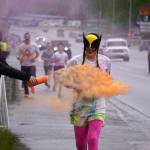 Attendees brave orange colored powder during a color run as part of the opening night of the Levitt AMP Soldotna Music Series along the Sterling Highway in Soldotna, Alaska, on Wednesday, June 5, 2024. (Jake Dye/Peninsula Clarion)
