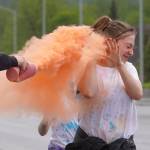 Attendees brave orange colored powder during a color run as part of the opening night of the Levitt AMP Soldotna Music Series along the Sterling Highway in Soldotna, Alaska, on Wednesday, June 5, 2024. (Jake Dye/Peninsula Clarion)