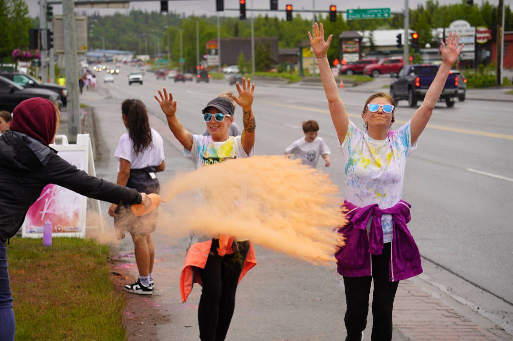Attendees brave orange colored powder during a color run as part of the opening night of the Levitt AMP Soldotna Music Series along the Sterling Highway in Soldotna, Alaska, on Wednesday, June 5, 2024. (Jake Dye/Peninsula Clarion)