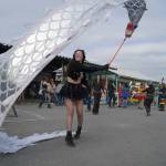 A performer dances with a long dragon flag at Salmonfest in Ninilchik, Alaska, on Saturday, Aug. 3, 2024. (Jake Dye/Peninsula Clarion)