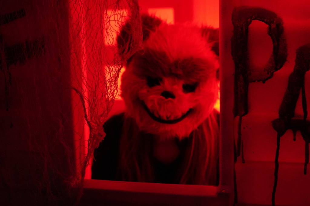 One frightening figure peers out from a doll house in the Haunted Chamber at the Kenai Chamber of Commerce and Visitor Center in Kenai, Alaska, on Friday, Oct. 18, 2024. (Jake Dye/Peninsula Clarion)