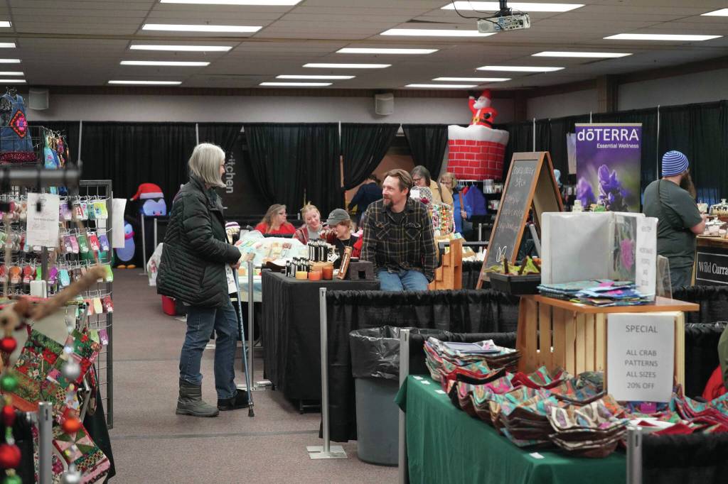 Jonas Oyoumick/Peninsula Clarion
Henry Dera, of Crooked Creek Birch, chats with shoppers at the 33rd Annual Holiday Bazaar at the Soldotna Regional Sports Complex on Friday.