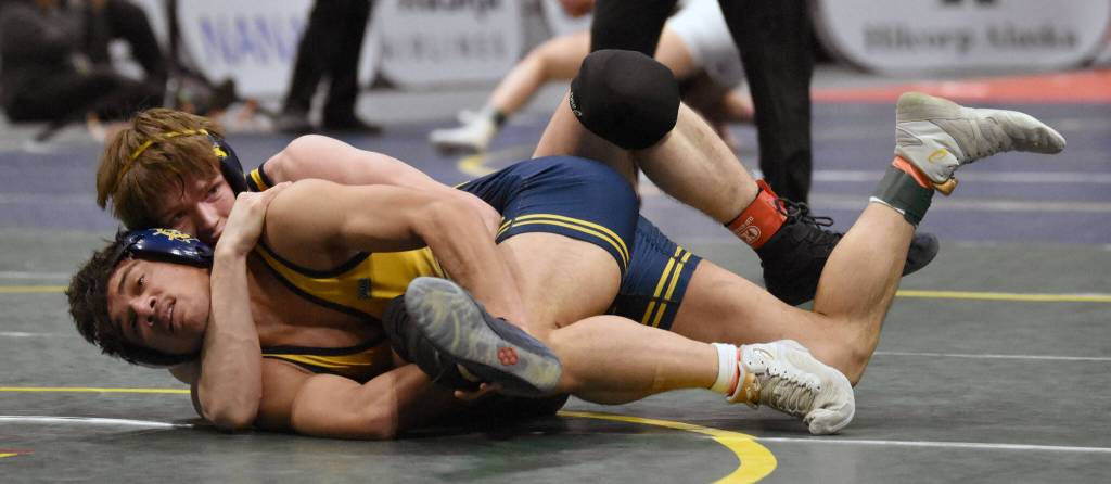 Homers Paul Minke (front) wrestles to a 12-4 major decision over Homers Justus Grimes in the final at 145 pounds at the Division II state wrestling tournament Saturday, Dec. 21, 2024, at the Alaska Airlines Center in Anchorage, Alaska. (Photo by Jeff Helminiak/Peninsula Clarion)