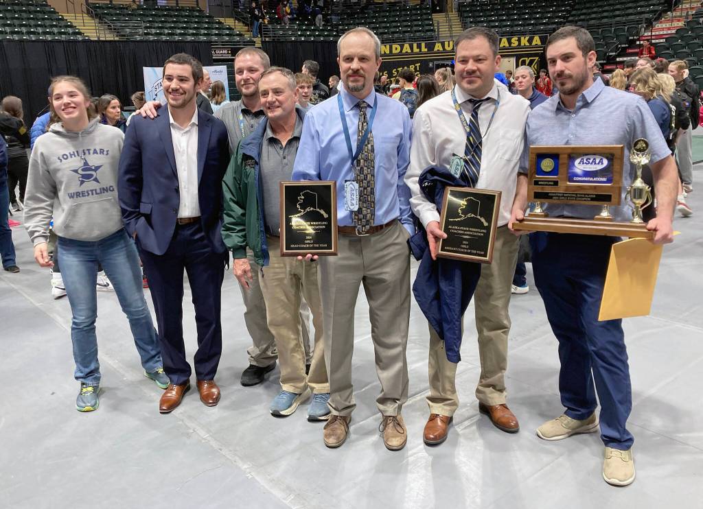 The Soldotna coaching staff of college athlete Trinity Donovan, assistant Sage Castillo, wrestling father Mark Hannevold, volunteer Neldon Gardner, head coach Pete Dickinson, assistant coach Max LeClair and assistant coach Phil Leck at the state wrestling tournament Saturday, Dec. 21, 2024, at the Alaska Airlines Center in Anchorage, Alaska. Dickinson and LeClair were named girls coaches of the year. (Photo by Jeff Helminiak/Peninsula Clarion)