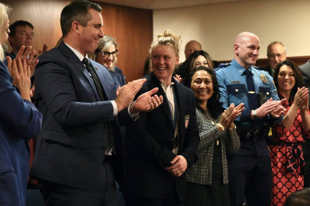 Olympic athlete Alev Kelter, center, smiles as shes recognized during Gov. Mike Dunleavys State of the State speech on Tuesday, Jan. 28, 2025, at the Alaska State Capitol. Next to Kelter is Dunleavys wife, Rose Dunleavy, and Alaska State Trooper Sgt. Jared Noll, who were also recognized during the speech. (Klas Stolpe/Juneau Empire)
