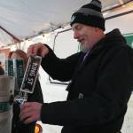 A brewer from King Street Brewing Company pours a cup for an attendee at the 10th Annual Frozen River Fest in Soldotna, Alaska, on Saturday, Feb. 15, 2025. (Jake Dye/Peninsula Clarion)