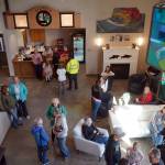 A stained glass chandelier and an infamous white couch brighten the lobby of the new Triumvirate Theatre in Kenai, Alaska, on Saturday, April 19, 2025. (Jake Dye/Peninsula Clarion)