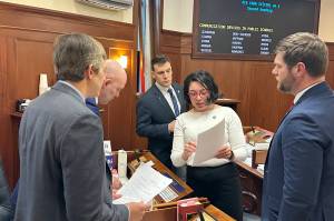 State Sen. Löki Tobin (D-Anchorage) reviews an amendment on an education bill with other senators during a break in floor debate Monday at the Alaska State Capitol. (Mark Sabbatini / Juneau Empire)
