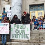 Geoff Kirsch and students from Sayéik Gastineau Community School sing during a rally for early education funding at the Alaska State Capitol on Tuesday, April 29, 2025. (Jasz Garrett / Juneau Empire)