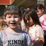 Students are covered in brightly hued powder during a color run at Kaleidoscope School of Arts and Science in Kenai, Alaska, on Saturday, May 3, 2025. (Jake Dye/Peninsula Clarion)