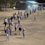 Students are covered in brightly hued powder during a color run at Kaleidoscope School of Arts and Science in Kenai, Alaska, on Saturday, May 3, 2025. (Jake Dye/Peninsula Clarion)