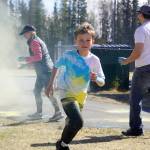 Students are covered in brightly hued powder during a color run at Kaleidoscope School of Arts and Science in Kenai, Alaska, on Saturday, May 3, 2025. (Jake Dye/Peninsula Clarion)