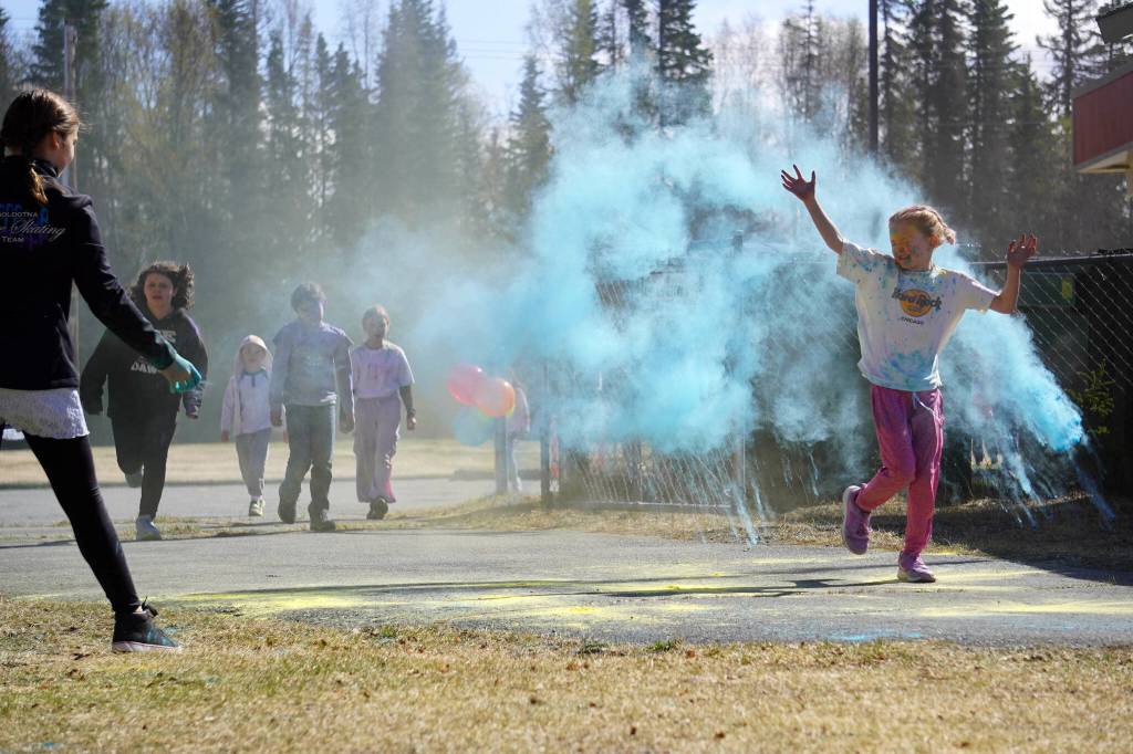 Students are covered in brightly hued powder during a color run at Kaleidoscope School of Arts and Science in Kenai, Alaska, on Saturday, May 3, 2025. (Jake Dye/Peninsula Clarion)