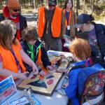 Students learn about salmon anatomy during Salmon Celebration, hosted by the Alaska Department of Fish and Game near Kasilof, Alaska, on Wednesday, May 7, 2025. (Jake Dye/Peninsula Clarion)