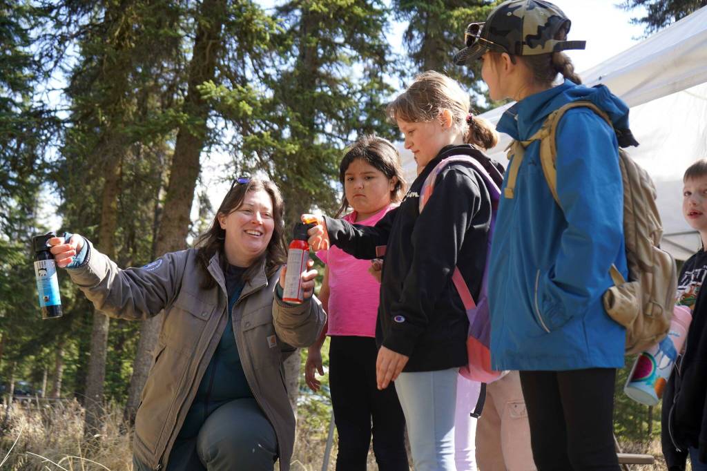 Students learn to safely and effectively deploy bear spray at a station run by the Alaska Wildlife Conservation Center during Salmon Celebration, hosted by the Alaska Department of Fish and Game near Kasilof, Alaska, on Wednesday, May 7, 2025. (Jake Dye/Peninsula Clarion)