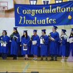 Kenai Alternative High School graduates stand with their diplomas at the conclusion of their commencement ceremony in the schools gym in Kenai, Alaska, on Wednesday, May 22, 2025. (Jake Dye/Peninsula Clarion)