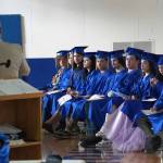 Kenai Alternative High School graduates listen to a speech by Principal John Galahan during their commencement ceremony in the schools gym in Kenai, Alaska, on Wednesday, May 22, 2025. (Jake Dye/Peninsula Clarion)