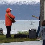 Musicians play and children wander as boats begin to gather offshore the Homer Spit on Tuesday, May 20 during the 2025 Blessing of the Fleet. (Chloe Pleznac/Homer News)