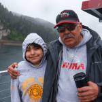 Frank Lee with his granddaughter aboard the catamaran approaching Hoonah on Friday, May 30, 2025. (Jasz Garrett / Juneau Empire)