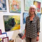 Artist Ingrid McKinstry stands next to her current mixed media exhibit and her work available year-round at Fireweed Gallery in Homer, Alaska. Photo provided by Ingrid McKinstry