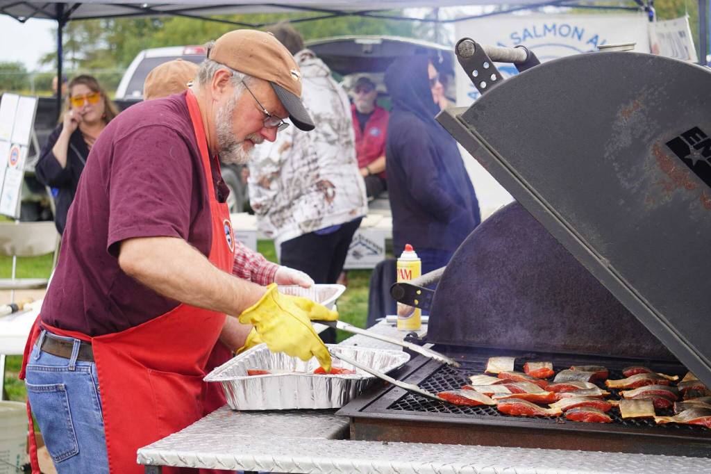Teague Vanek grills up salmon during the 2025 Industry Appreciation Day at the Kenai Softball Greenstrip in Kenai, Alaska, on Saturday, Aug. 23, 2025. (Jake Dye/Peninsula Clarion)