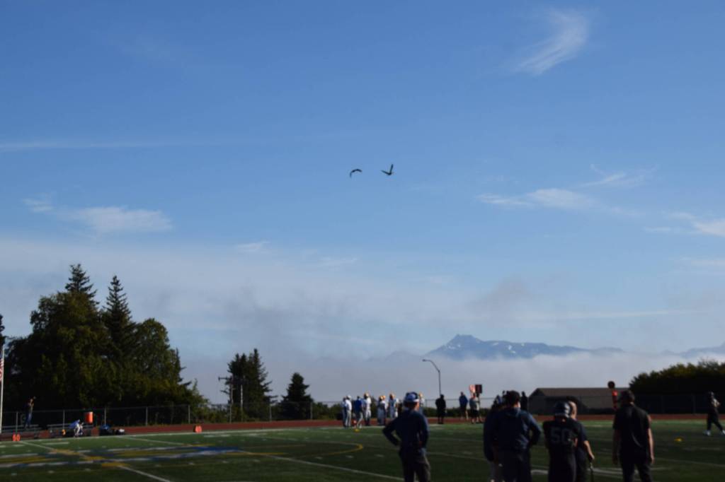 A pair of sandhill cranes fly over the game. (Chloe Pleznac/Homer News)