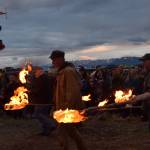 Torch bearers prepare to light the basket on Sunday, Sept. 7, 2025, at Mariner Park in Homer, Alaska. (Chloe Pleznac/Homer News)
