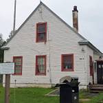 The historic marker in front of this building at 502A Overland Avenue in Kenai identifies the structure as the former headquarters of the Kenai National Wildlife Refuge and the site of the former Agricultural Experiment Station, 1899-1908. Photo by Clark Fair