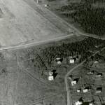 This 1946 Walter Smith aerial photograph is one of the latest known images to show the old quarters of the agricultural experiment station at Kenai. The log structure (seen directly above a more recent building just to the left of curving Overland Avenue), built in 1901, was razed in the early 1950s to make room for a modern garage/maintenance shop for the U.S. Fish & Wildlife Service.