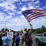 People carrying flags and signs line the Sterling Highway for a "No Kings" protest in Soldotna, Alaska, on Saturday, June 14, 2025. (Jake Dye/Peninsula Clarion)